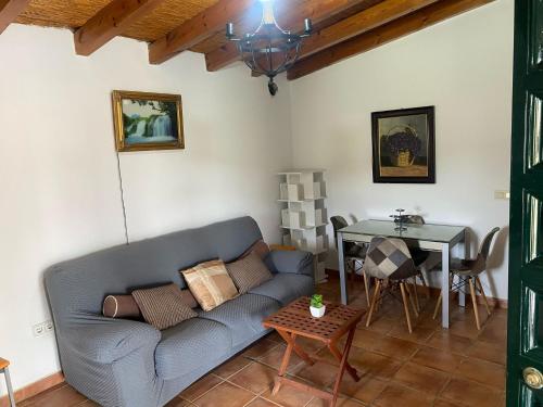 een woonkamer met een bank en een tafel bij Cortijo Bachiller Alora 18 personas Fiestas tranquilas in Alora