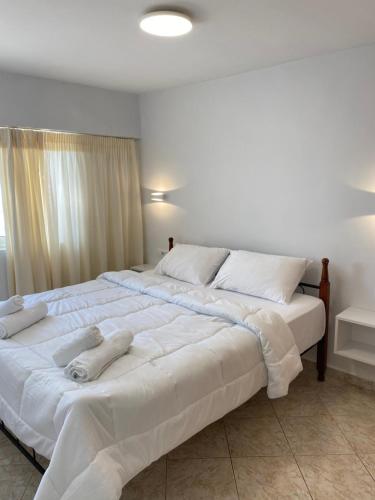 una camera da letto con un grande letto bianco con asciugamani sopra di Thea Studios a Sarandë