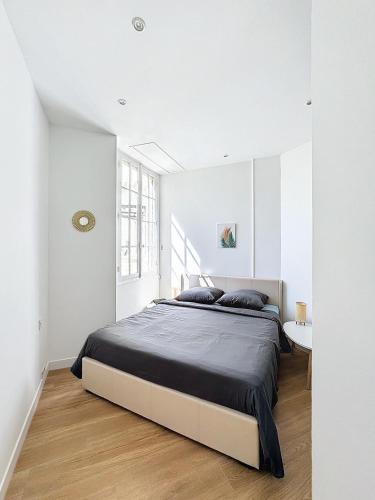 une chambre blanche avec un grand lit et une table dans l'établissement 2 pièces à 5 minutes des plages avec Parking, à Antibes