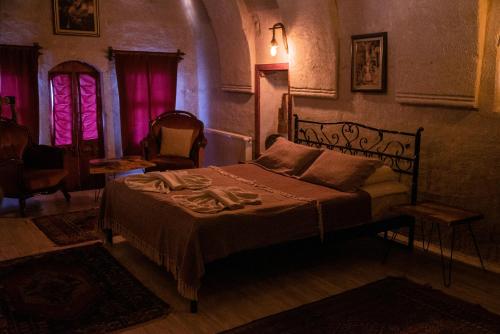 a bedroom with a bed in a room with pink lights at Zen Cappadocia in Uchisar