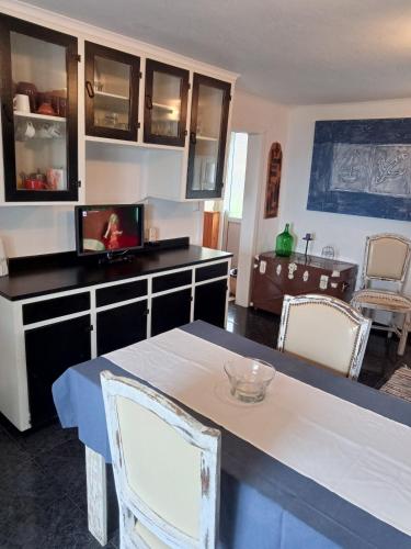 a kitchen with a table and chairs in a room at O Anexo in Angra do Heroísmo