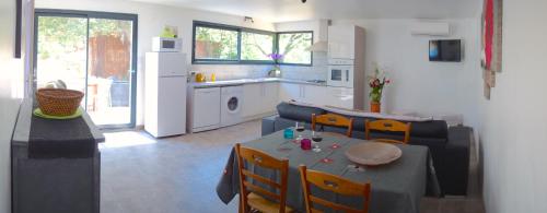 eine Küche und ein Wohnzimmer mit einem Tisch und Stühlen in der Unterkunft Le Clos Saint Elme in Collioure