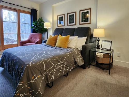 a bedroom with a large bed and a chair at Tremblant Prestige - Étoile 1500-2 in Mont-Tremblant