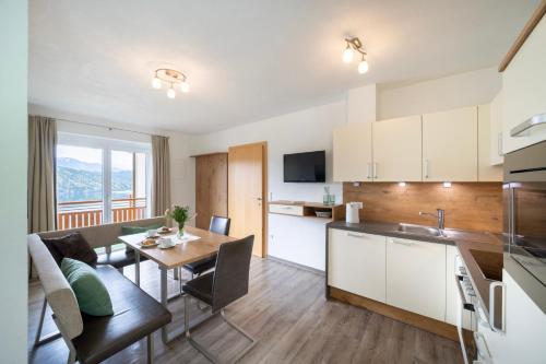 a kitchen and living room with a table and a dining room at Frühstückspension Götzfried-Hof in Millstatt