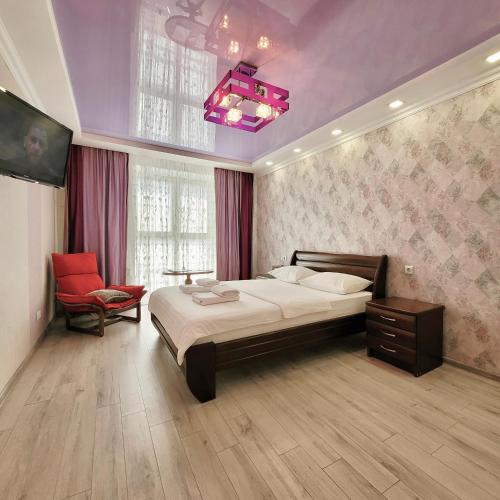 una camera con un grande letto e un soffitto viola di ApartPoltava Шикарна панорама ЦЕНТР апартаменти в елітній НОВОБУДОВІ, Документація для відрядження a Poltava