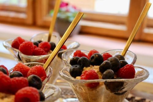 three bowls of fruit on a table with wooden sticks at Pensiunea Agora in Cisnadioara