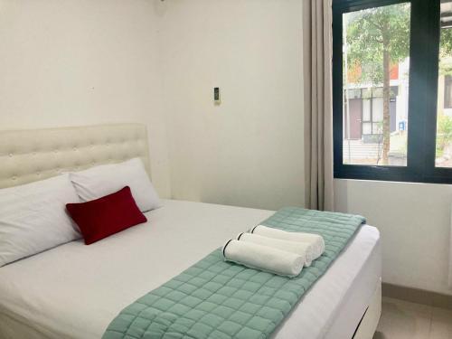 a bedroom with a bed with a red and white pillow at RAM Homestay Sharia, 5 Adults 1 Child, Ideal Stay Between Bromo & South Malang Beaches in Bareng