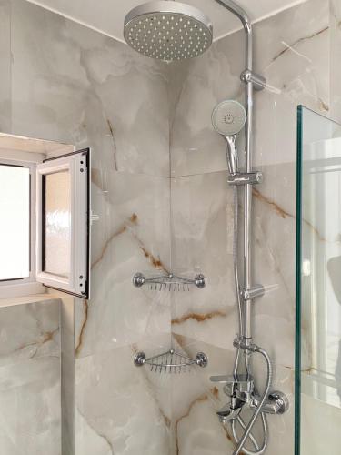 un bagno con doccia con porta in vetro di Thea Studios a Sarandë