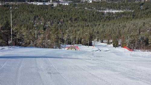 a snow covered road with a fence on the side of a mountain at LEVI Tunturinlaita A4, Ski-in Ski-out 3xBedroom in Levi