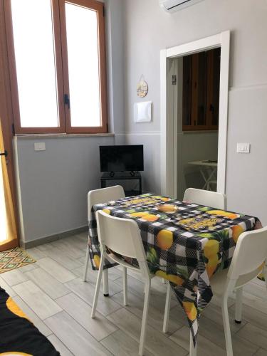 a dining room with a table and chairs and a television at Sicily Sud-Est in Avola