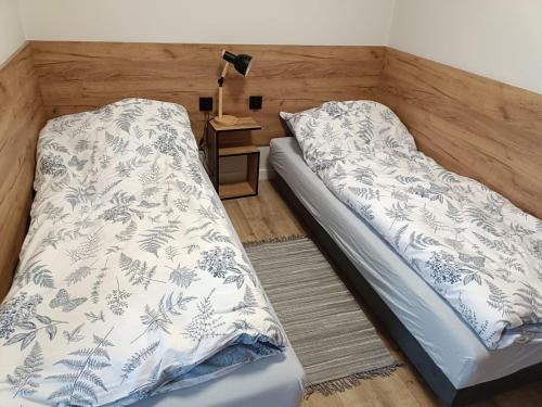 a bedroom with a bed and a table with a lamp at Pigwowcowe Zacisze in Grabowa