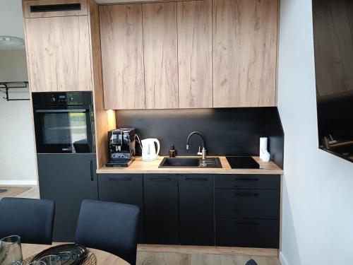a kitchen with wooden cabinets and a sink at Pigwowcowe Zacisze in Grabowa