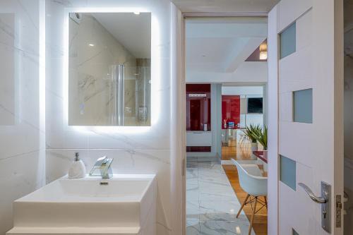 a white bathroom with a sink and a mirror at Old Town - EuroEastVentures Luxury Properties in Bucharest