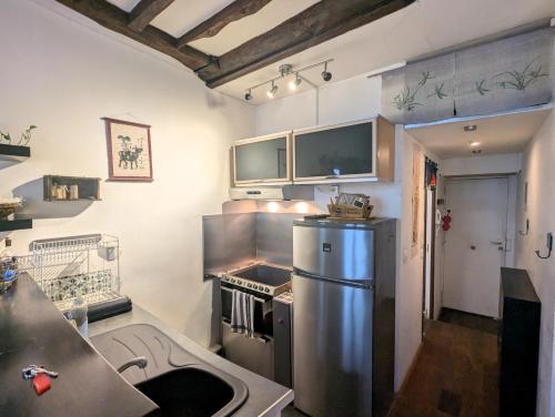 une cuisine avec un réfrigérateur en acier inoxydable et un évier dans l'établissement Charming pied-à-terre - Marais, à Paris