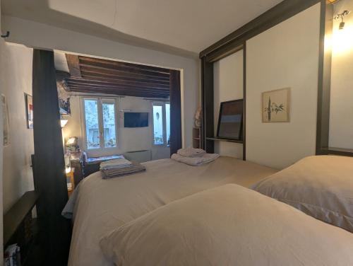 une chambre avec deux lits et une fenêtre dans l'établissement Charming pied-à-terre - Marais, à Paris