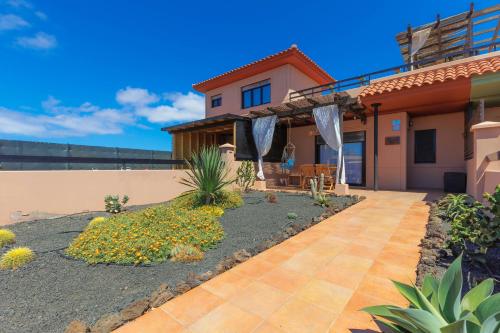 una casa con un sentiero che conduce al cortile anteriore di Alinico House a Majanicho