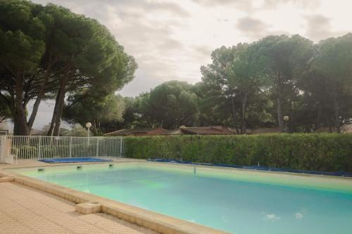 une grande piscine bleue dans une cour dans l'établissement Aux portes de la Nature, au Cap d'Agde