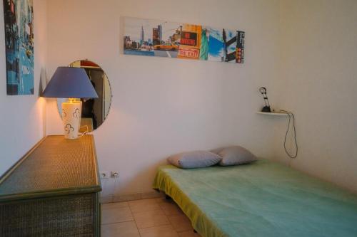 - une chambre avec un lit, un miroir et une lampe dans l'établissement Aux portes de la Nature, au Cap d'Agde