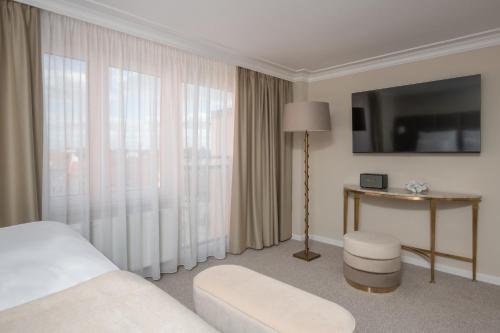 a hotel room with a bed and a table and window at Mamma´s Boutique Hotel in Poděbrady