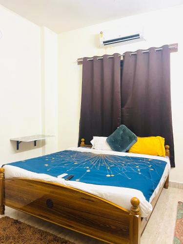 a bedroom with a wooden bed with a black curtain at Coral Mahabs in Mahabalipuram