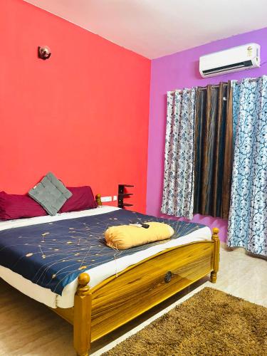 a bedroom with a bed with red and purple walls at Coral Mahabs in Mahabalipuram