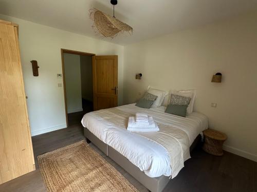 a bedroom with a large white bed with towels on it at Chambre d'hôtes Le Mas Vidal in Nîmes