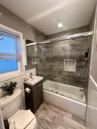 a bathroom with a tub and a toilet and a sink at Wavecrest Resort in Montauk