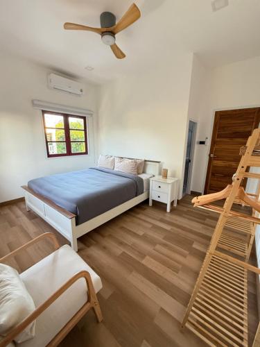 a bedroom with a bed with a ceiling fan and a ladder at Bophut Fisherman's Village Pink Sky Villa in Koh Samui 