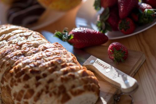 a loaf of bread and strawberries on a table at Tylawa - Domki w Beskidzie Niskim in Tylawa