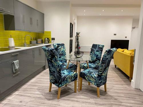 a kitchen with a glass table and two chairs at Bright & Cosy Retreat in Swansea in Swansea