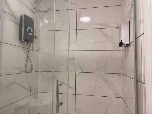 a bathroom with a shower with a glass door at Bright & Cosy Retreat in Swansea in Swansea