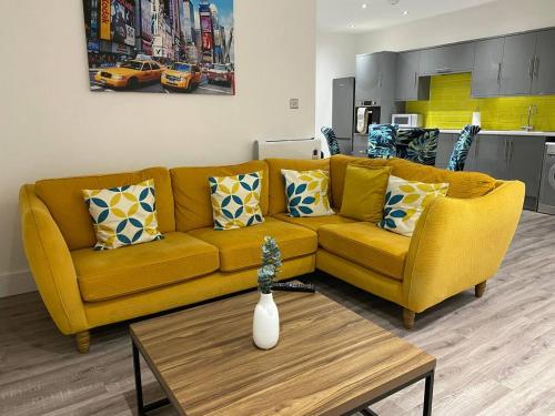 a living room with a yellow couch and a table at Bright & Cosy Retreat in Swansea in Swansea