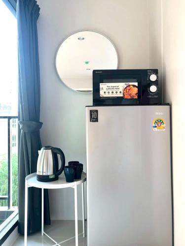 a white refrigerator with a microwave on top of it at 4 mins to MRT Sutthisan in Bangkok