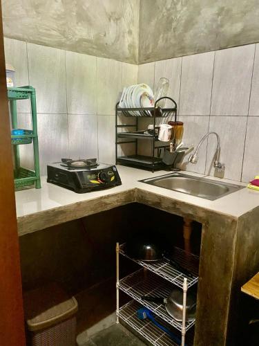 a kitchen counter with a sink and a sink at Tebeduwe Joglo Villa in Mambat