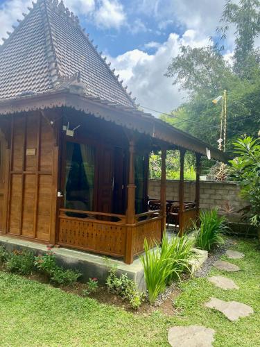 a wooden gazebo in front of a house at Tebeduwe Joglo Villa in Mambat