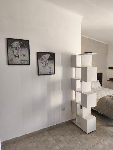 a bedroom with a white wall with a book shelf at Departamento Pellegrini in San Pedro