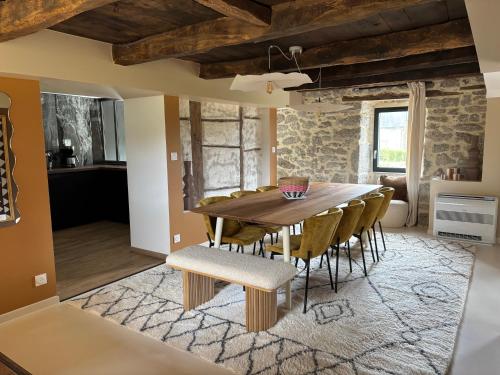 une salle à manger avec une table et des chaises en bois dans l'établissement La Longère - Gîte 4 étoiles, à Alleyrat