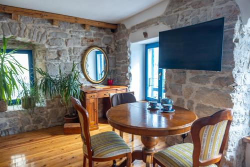 un soggiorno con tavolo in legno e parete in pietra di Old House a Vodice