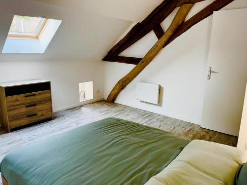 an attic bedroom with a bed and a dresser at Assarag in Brienon-sur-Armançon