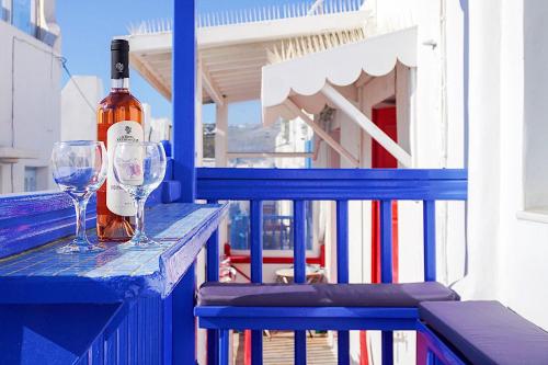 a bottle of wine and two glasses on a blue table at Pension Ageliki Kalogera in Mikonos