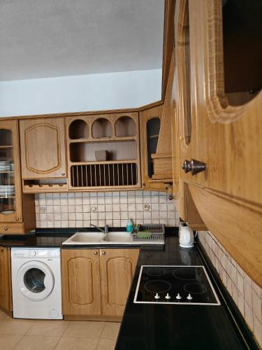 a kitchen with wooden cabinets and a stove top oven at Sliema 3 bedrooms apartment in Sliema