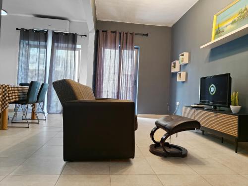 a living room with a chair and a tv at Sliema 3 bedrooms apartment in Sliema