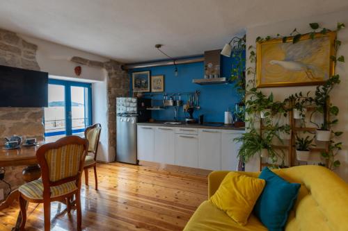 un soggiorno con divano giallo e una cucina di Old House a Vodice