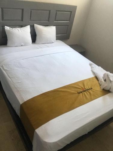 a large white bed with a blanket on it at Hotel Sharidia Inn in Veracruz