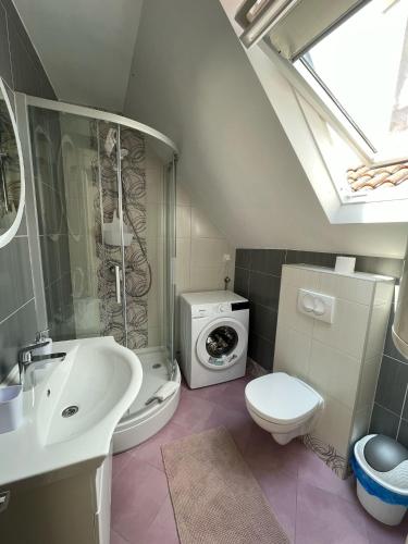 a bathroom with a sink toilet and a washing machine at Apartments & Room Nina in Korčula