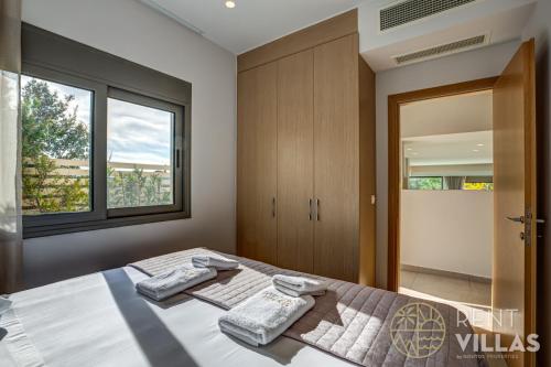 a bedroom with a bed with two towels on it at A1 - Luxury house with pool by goutos properties in Porto Heli