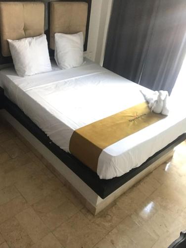 a bed in a room with white sheets and pillows at Hotel Sharidia Inn in Veracruz