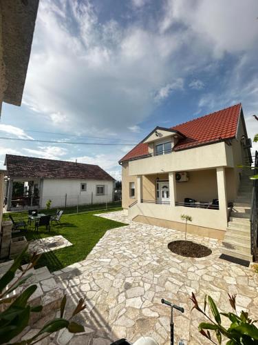 a house with a red roof and a patio at Airport Apartments MM in Golubovci
