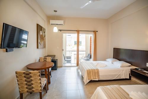a room with two beds and a table and a television at Gran SAHARA in Playa del Carmen