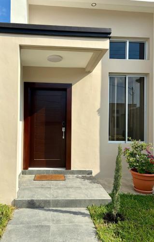 a front door of a house with a plant at Tu hogar en Casa Valencia in San Pedro Sula